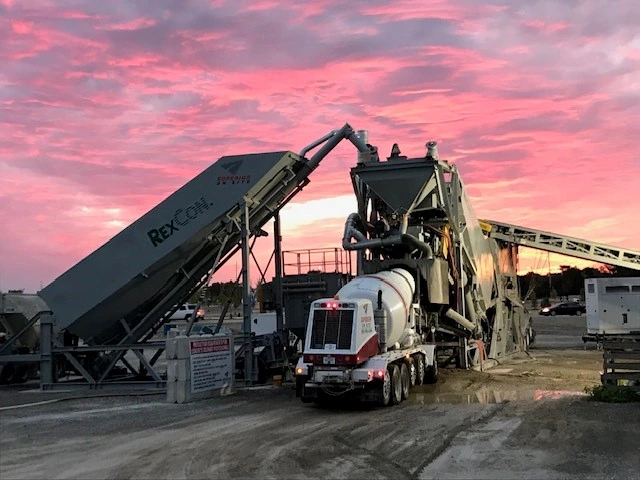 Ready Mix Concrete Services in Southeast Michigan - Superior Materials mixer truck loading at a portable plant at dusk