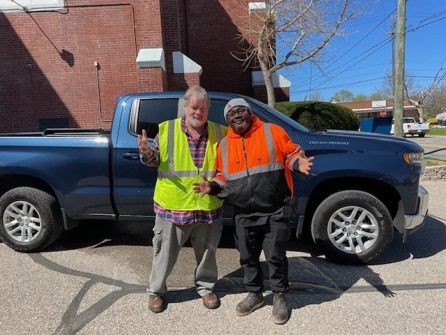 Construction Industry Community Initiatives - two Superior Materials volunteers in safety vests beside a pickup truck